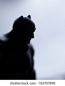 Studio Image Of Batman Action Figure Silhouetted Against Backlit Surface And Dramatic Lighting. Batman Is A DC Comics Character Also Known As The Dark Knight And Caped Crusader.