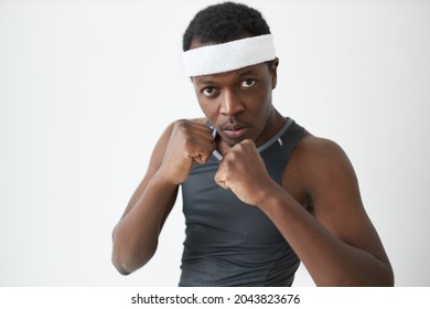 Studio Image Of Dark-skinned Athlete Holding Fists In Front Of Him In Defensive Stance, Looking At Camera With Serious, Concentrated Face. People, Sport, Competition. Body Language