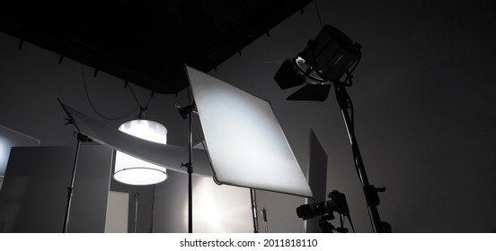 Studio Light Equipments For Photo Or Film Movie Video. Light Set For Professional Shooting Studio Background. LED Flood Light And Spot Light For Video Production Studio. Setup Barn Door And Softbox.