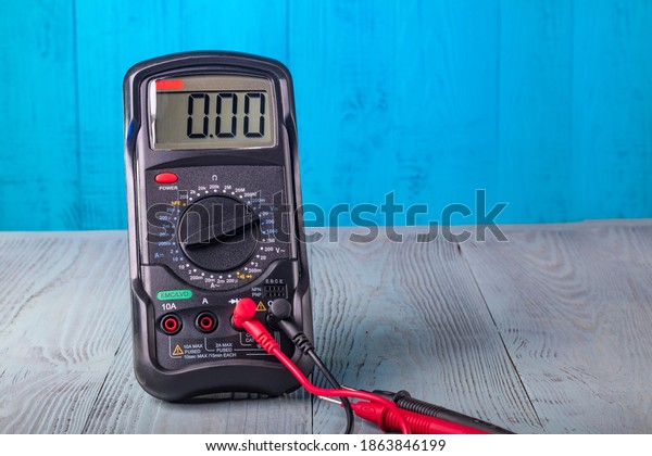Studio lighting. wooden\
background in retro style with stained glass painting. Voltmeter.\
Close-up.