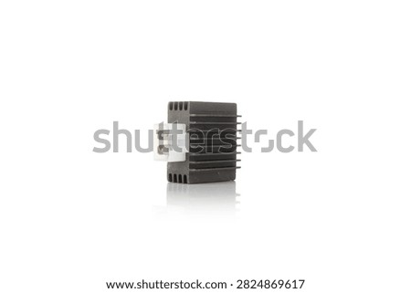 Studio macro close up of motorcycle voltage regulator rectifier featuring black cast aluminum heat sink cooling fins, white plastic side socket pin connector, three quarter angle perspective, and soft mirror reflection, isolated on pure white background for auto parts mockup.