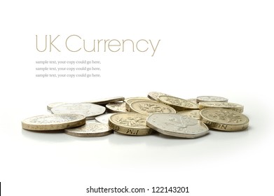 Studio macro image of UK currency coins with soft shadows against a white background. Copy space.