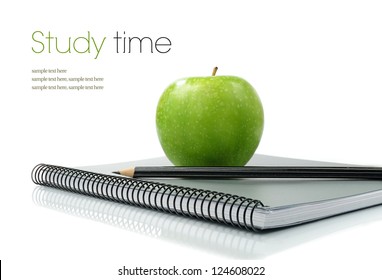 Studio macro of shiny green apple, pencil and new notebook on a white surface. Copy space. - Powered by Shutterstock