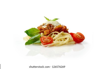 Studio macro of Spaghetti Bolognese meal with basil leaves, grated parmesan cheese and tomatoes. Copy space.