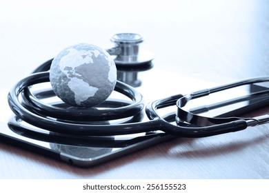 Studio macro of a stethoscope and texture globe with digital tablet with shallow DOF evenly matched abstract as medical network concept