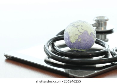 Studio macro of a stethoscope and texture globe with digital tablet with shallow DOF evenly matched abstract as medical network concept