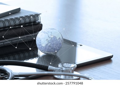 Studio macro of a stethoscope and texture globe with digital tablet with shallow DOF evenly matched abstract as medical network concept