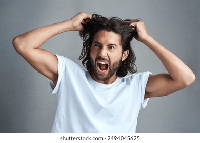 Studio, man and frustrated with pulling of hair for bad news, stress and anxiety on gray background. Angry, male person and expression with screaming for panic attack, mental health and ptsd trauma - Powered by Shutterstock