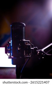 A studio microphone in dramatic lighting setup with soft focus background, perfect for podcast, music, and voiceover themes. Vivid colors and bokeh add a cinematic touch.