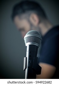 Studio microphone in front of a singer in a studio, selective focus