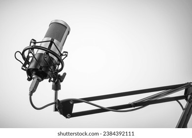 Studio microphone on the mic stand with gray background. Concept for podcast or sound recording. Copy space.