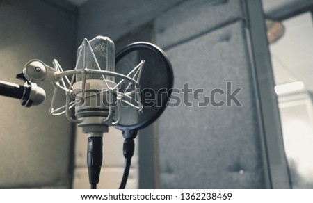 Studio microphone with shock mount and pop filter on professional tripod in acoustic foam room for best sound production on air and mix process in music industry and high quality broadcasting