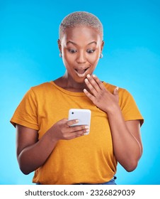 Studio, phone and black woman surprise over reading announcement, winner notification or online sales news. Discount promotion, smartphone information and shocked African person on blue background - Shutterstock ID 2326829039