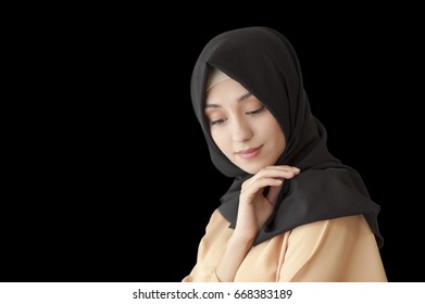 Studio photo of a beautiful young woman eastern type full-length, on a black background, dressed in the Muslim style