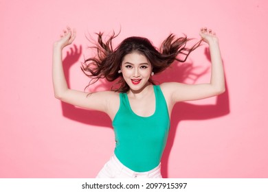 Studio Photo Of Inspired Asian Lady Dancing Isolated On Pink Background.