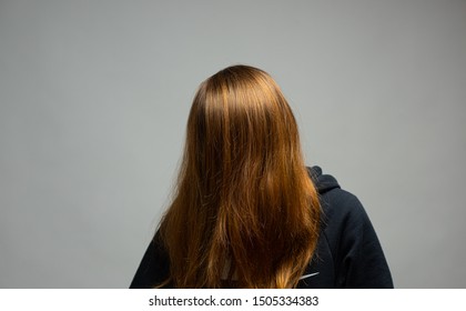Studio photo of long- and brownhaired person with hair in front of the eyes. - Shutterstock ID 1505334383