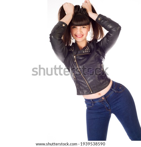 Studio photo of the model I do not know. Portrait of a confused beautiful brunette young woman with makeup in casual style jeans, standing with raised hands, looking and doubt. 