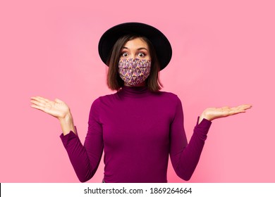 Studio  Photo  Of Young  Brunette  Girl  Wearing Respiratory Face Mask Against Coronavirus. Background Of  Pink Color With Copy Space. Suprise Face.