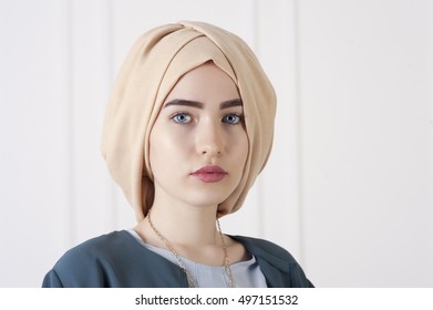 Studio photo of a young woman eastern type in the modern Muslim clothes and beautiful headdress