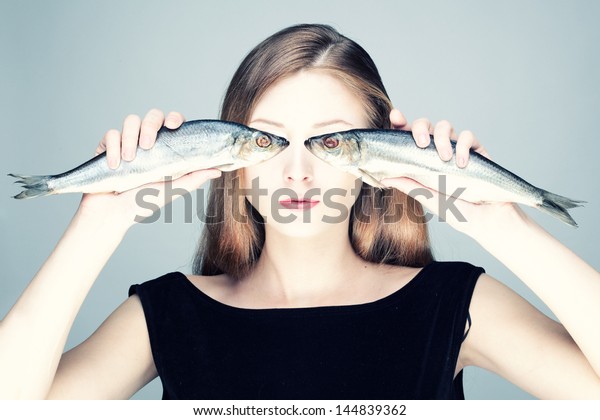Studio photo of a\
young woman with the\
fishes