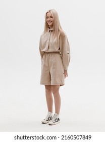 Studio Photoshoot Of A Smiling Young Blond Woman Wearing Casual Clothing Against A White Background.  Natural Makeup And Hairstyle.