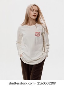 Studio Photoshoot Of A Smiling Young Blond Woman Wearing Casual Clothing Against A White Background.  Natural Makeup And Hairstyle.