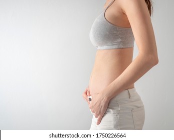 Studio Portrait of 2 months Pregnant Woman on white background. 