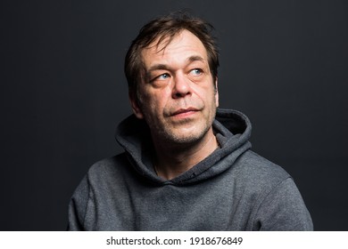 Studio Portrait Of A 40-50-year-old Man In A Gray Hoodie On A Neutral Background, Close-up, Eyes Directed To The Side. Maybe He's An Actor Or A Truck Driver, A Lawyer, Or A Retired Military Man.