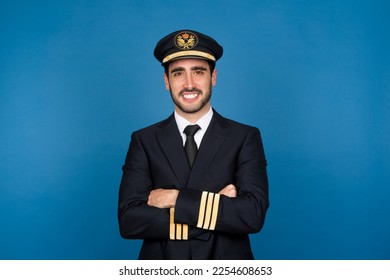 Studio portrait of an airline pilot in black uniform smiling at the camera - Powered by Shutterstock