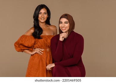 Studio portrait of an Arab Muslim woman in her 20's and an Indian woman in her 30's confidently looking at the camera on a neutral background. Stock Photo