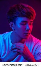 Studio Portrait Of Asian Man With Red And Blue Light.