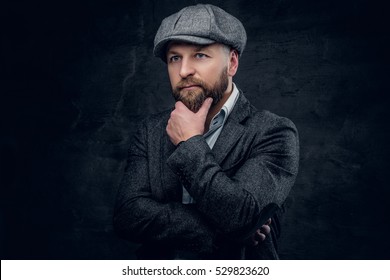 Studio Portrait Of Bearded Englishman In Woolen Hunting Jacket And Tweed Cap.