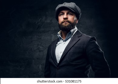 Studio Portrait Of Bearded Englishman In Woolen Hunting Jacket And Tweed Cap.