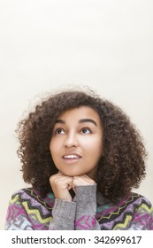 Studio Portrait Of Beautiful Happy Mixed Race African American Girl Teenager Female Young Woman Looking Up Thinking, Dreaming Or Wishing