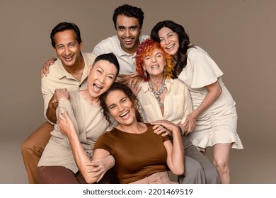 Studio portrait of beautiful multiracial people laughing together on a neutral background. Stock Photo