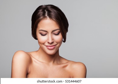 Studio portrait of a beautiful young woman with brown hair. Pretty model girl with perfect fresh clean skin. Beauty, wellness, people, healthy lifestyle, fashion model and skin care concept