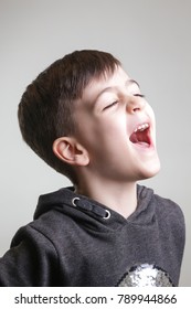 Studio Portrait Of Boy Laughing - Side View