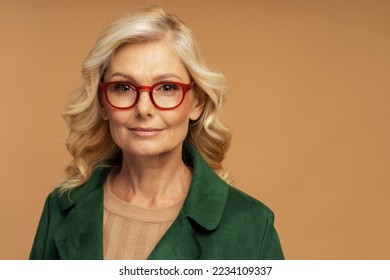 Studio portrait of confident mature businesswoman wearing stylish red  eyeglasses isolated on background. Successful business concept   - Powered by Shutterstock