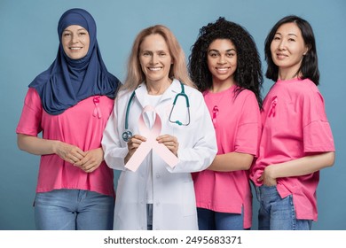 Studio portrait of diverse group of women wearing pink t-shirts and a doctor holding a pink ribbon, united in their support for breast cancer awareness. Health care concept - Powered by Shutterstock