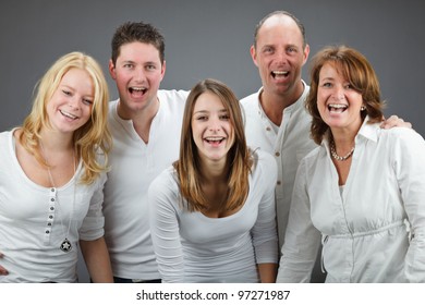 Studio Portrait Of Family With White Shirt Isolated On Grey Background