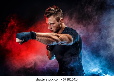 Studio portrait of fighting muscular man in smoke