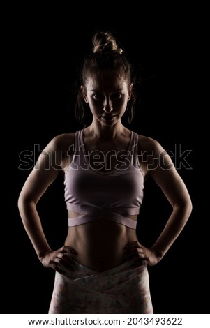 Similar – Close up front portrait of one young athletic woman in sportswear in gym over dark background, standing in boxing stance with hands and fists, looking at camera