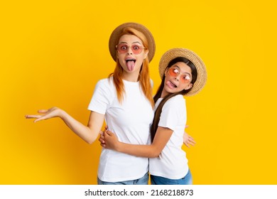 Studio Portrait Of Funny Child With Mum. Funny Face. Mother And Teenager Daughter Hugging Lovely Cuddling, Wearing White T-shirts Straw Hat And Sunglasses, Isolated On Bright Yellow Background.