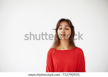 Studio portrait of funny goofy young Latin brunette woman having fun indoors, fooling around, making faces and squinting eyes, trying to see tip of her nose. People, leisure, fun and relaxation