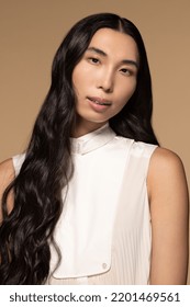 Studio Portrait Of Gorgeous Taiwanese Transgender Woman With Long Black Hair On A Neutral Background Looking At The Camera