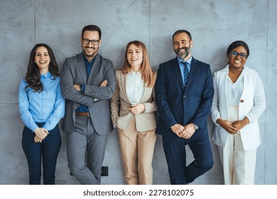 Studio portrait of a group of businesspeople posing against a gray background. Portrait of multi-ethnic male and female professionals. Business colleagues are standing against wall. - Shutterstock ID 2278102075