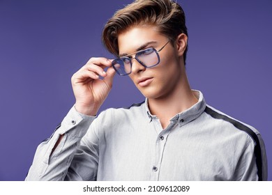 Studio portrait of handsome young guy in stylish eyewear wearing shirt while looking away. Isolated on purple background. Stylish hairstyle . Fashion man  - Shutterstock ID 2109612089