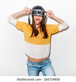 Studio Portrait Of A Happy Crazy Hipster Girl With Camera In A Yellow Bike And Jeans On White Background