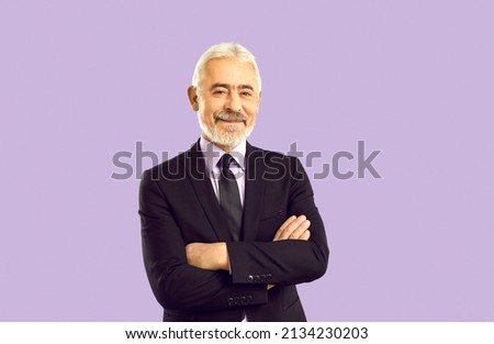 Studio portrait of happy experienced businessman, company founder and business professional. Cheerful white haired senior man in smart suit, shirt and elegant tie isolated on solid purple background