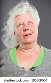 Studio Portrait Of Happy Senior Woman With Long Hair In The Wind. Studio Shot Isolated On Grey Background.